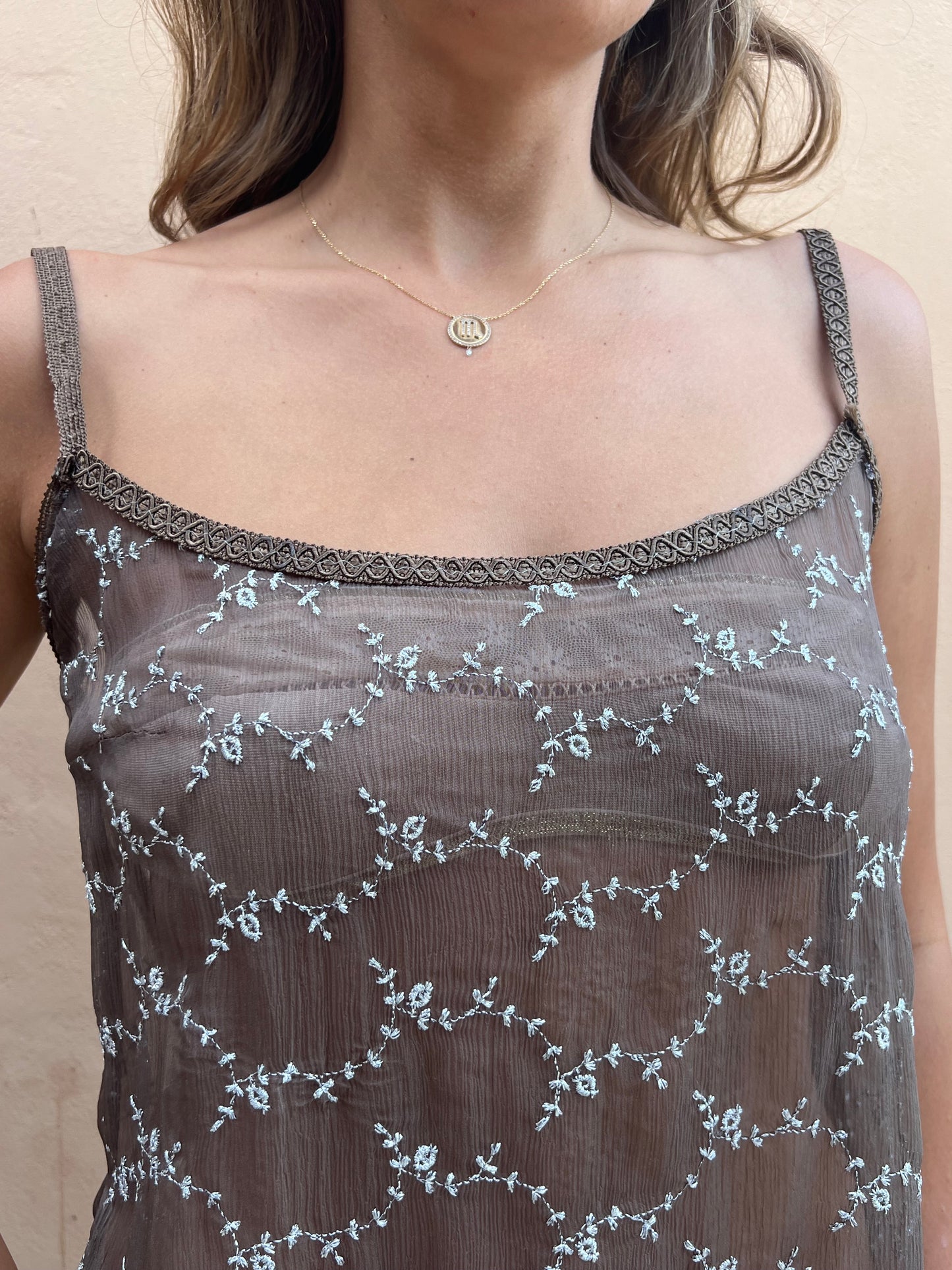 Close-up of a sheer lace garment with floral patterns on a neutral background